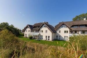 eine Reihe von Häusern an der Seite eines Hügels in der Unterkunft Ferienwohnung Sanddorn - Strandhaus Lobbe in Lobbe