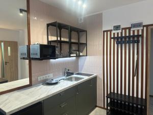 a small kitchen with a sink and a microwave at VISTA Apartment in Mińsk Mazowiecki