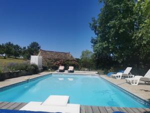 una piscina con sedie a sdraio e una casa di Gite de caractère, piscine et vue a Le Boulvé