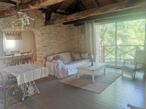 un soggiorno con un divano e un tavolo di Gite de caractère, piscine et vue a Le Boulvé