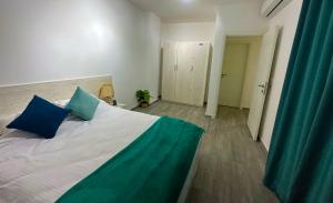 a bedroom with a large bed with blue pillows at Imperial Resort Apartment XL 1 Bed in Hurghada