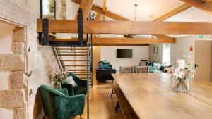 uma sala de estar com um loft com uma mesa e cadeiras em Holly Bush Farm em Matlock