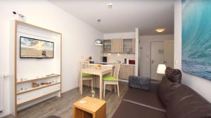 un soggiorno con un divano, un tavolo e una cucina di Ferienwohnung Sonnensegler Wohnung 220 a Baabe