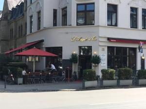 un ristorante con tavoli e sedie di fronte a un edificio di FlatDeCologne VeeDel a Colonia