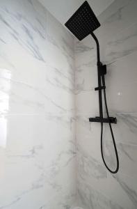 a bathroom with a shower with white marble walls at Charmant 2 pièces à Issy- les -Moulineaux in Issy-les-Moulineaux
