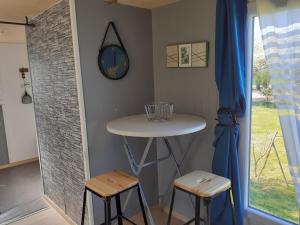 mały stolik i dwa stołki w pokoju w obiekcie La sablière w mieście Oucques