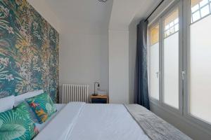 a bedroom with a large bed and a window at Charmant 2 pièces à Issy- les -Moulineaux in Issy-les-Moulineaux