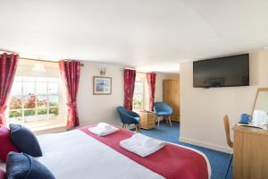 a hotel room with a bed and a flat screen tv at The Kings Head in Deal