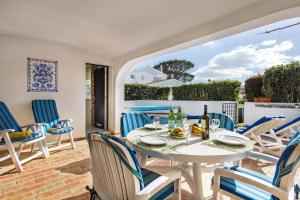 a patio with a white table and chairs on a balcony at Mng Elliott55 in Vale do Lobo