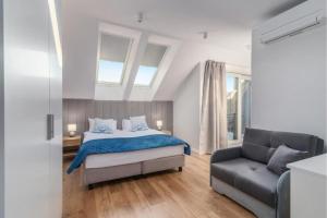 a bedroom with a bed and a couch at Apartamenty Statki na Niebie in Rowy