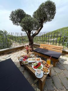 a picnic table with food on it with a tree at Grey Escape in Qalḩāt