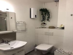ein weißes Bad mit einem Waschbecken und einem WC in der Unterkunft FlatDeCologne VeeDel in Köln