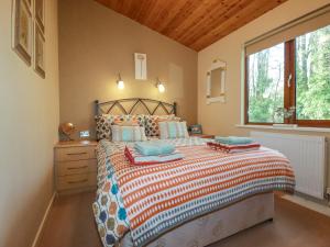 Un dormitorio con una cama grande y una ventana. en 4 The Glade, en Wadebridge