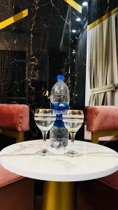 a bottle of water sitting on a table with two glasses at High Rise Executive Apartments Facing Centaurus Mall Islamabad in Islamabad