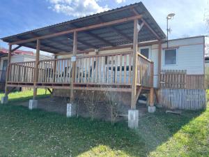 ein Haus mit einer Holzterrasse mit einem Dach in der Unterkunft Mobilheim Josefína - Výrovická přehrada in Výrovice