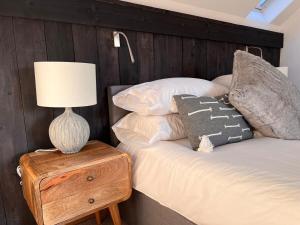 a bed with a wooden headboard and a lamp on a table at Stunning Dovey View - Ynyshir in Machynlleth