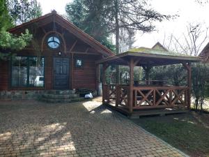 a gazebo with a clock on top of it at Domki nad Jeziorem Ołów in Ryn
