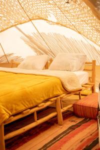 a bedroom with a bed in a tent at La Ferme des Tipis Marrakech in Marrakech