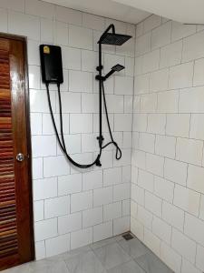 a shower in a white tiled wall with a shower at The Sol on the sea - Koh Lanta in Ko Lanta
