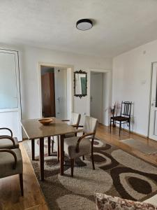 sala de estar con mesa de madera y sillas en Skyland Apartment Prizren, en Prizren