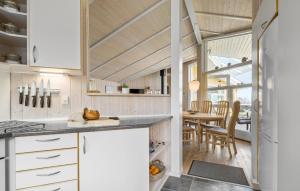 SkovbyにあるNice Home In Sydals With 4 Bedrooms, Sauna And Wifiの白いキャビネット付きのキッチン、ダイニングルーム