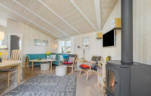 a living room with a fireplace and a dining room at Holiday Home Sydals 57 With Hot Tub in Skovby