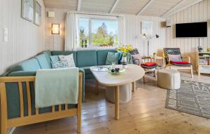 a living room with a couch and a table at Holiday Home Sydals 57 With Hot Tub in Skovby