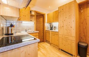 eine Küche mit Holzschränken und einer Arbeitsplatte in der Unterkunft Nice Apartment In Wagrain With 3 Bedrooms And Wifi in Wagrain