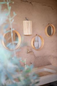 uma casa de banho com 2 espelhos, um lavatório e uma luz em La Ferme des Tipis Marrakech em Marraquexe