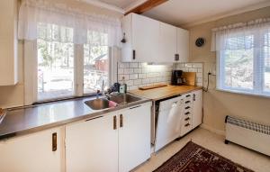 a kitchen with white cabinets and a sink at Lovely Home In Alingss With Lake View in Alingsås