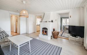 a living room with a fireplace and a tv at Lovely Home In Alingss With Lake View in Alingsås