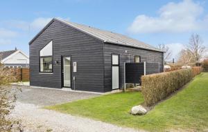 a black and white house with a yard at Awesome Home In Otterup With Wifi in Otterup +10 photos