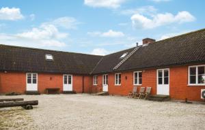 eine Reihe roter Backsteingebäude mit weißen Türen in der Unterkunft 3 Bedroom Lovely Home In Borrby in Borrby