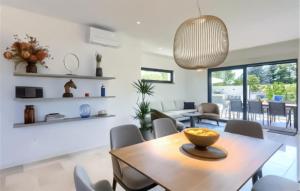 a dining room and living room with a table and chairs at Awesome Home In Basanija With Kitchen in Bašanija
