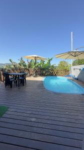 eine Terrasse mit einem Picknicktisch und einem Pool in der Unterkunft Casa dos Gerânios com Piscina - Próximo ao Parque Termal! in Piratuba