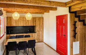 uma sala de jantar com uma porta vermelha e uma mesa e cadeiras em Lovely Home In Rowy With Wifi em Rowy