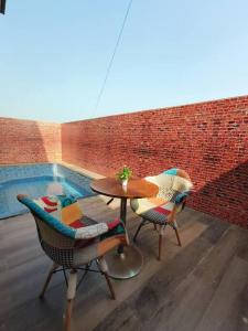 Lavish 3BHK Villa F2 - Private Pool - The Heaven في Pālghar: فناء مع طاولة وكراسي بجوار حمام سباحة