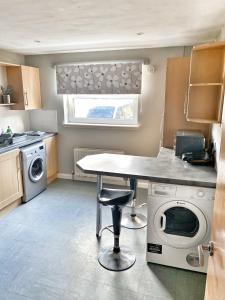 - une cuisine avec une table et un lave-linge dans l'établissement Spacious Ground floor, 2 bed by Lains Lettings m, à Aberdeen