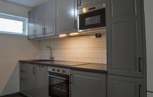 a kitchen with a sink and a microwave at 2 Bedroom Amazing Apartment In Skrholmen in Stockholm