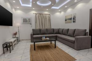 a living room with a couch and a table at Comfortable & Big Family Apartments 10Mins Drive to Al-Masjid -Nabawi in Medina