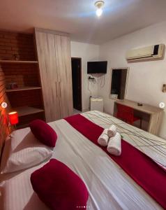 a bedroom with a large bed with red and white pillows at Pousada Baobá in Olinda