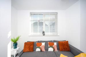 a living room with a gray couch with orange pillows at Matson Road Ipswich in Ipswich