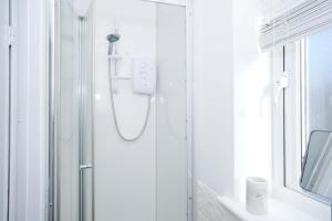 a bathroom with a shower with a mirror and a window at Matson Road Ipswich in Ipswich