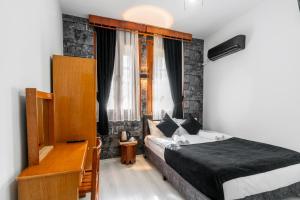 Schlafzimmer mit einem Bett, einem Schreibtisch und einem Fenster in der Unterkunft BÜTÜNOĞLU PANSİYON in Antalya