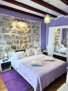 1 dormitorio con 1 cama grande y pared de piedra en Apartment Maris, en Dubrovnik