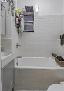 a bathroom with a tub and a toilet and a sink at 1 Bedroom Apartment East Village Union Square in New York