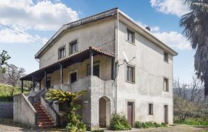 une ancienne maison en pierre avec un escalier en face de celle-ci. dans l'établissement 4 Bedroom Cozy Home In Cetraro - San Pietro, 