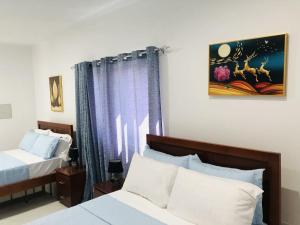 una camera d'albergo con due letti e una finestra di Edificio Cosec Hotel a Cova Figueira