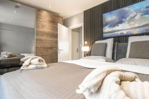 a bedroom with two beds and a large screen at Beach House Penthousewohnung Düne in Timmendorfer Strand