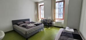 1 dormitorio con cama, mesa y ventanas en ToTa Studio en Viena